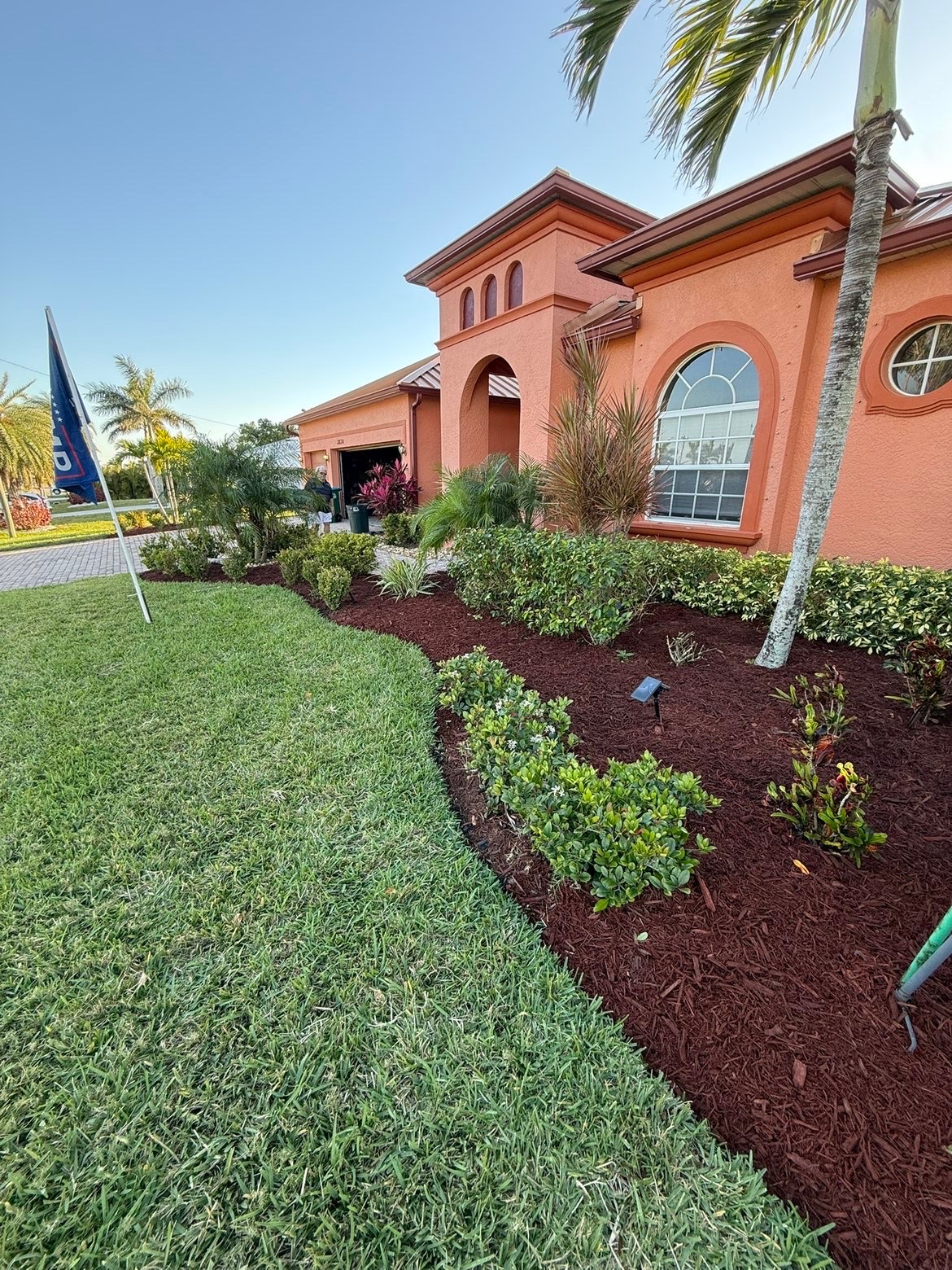 Full landscape install with shrubs and red mulch beds